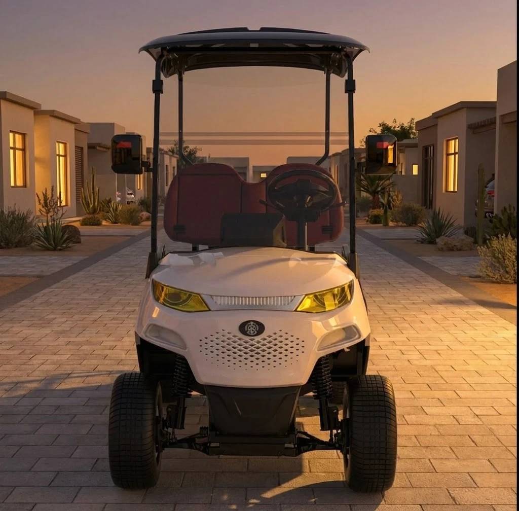 White golf cart on a paved driveway with houses in the background during sunset.
