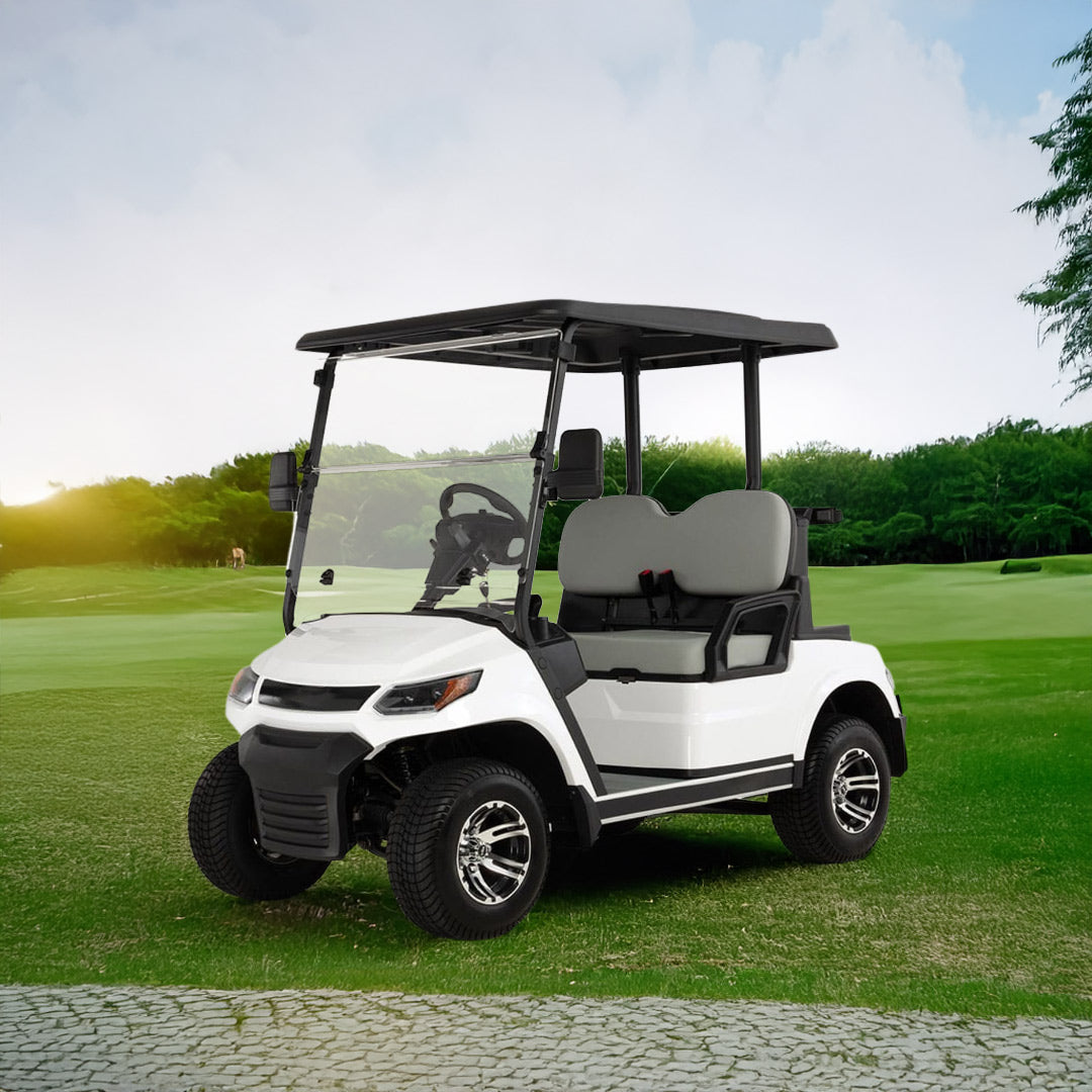 UAE golf cartz three-quarter front view of a white four-seater golf cart with a black roof, parked on a lush green golf course. This electric vehicle features gray seats, a full windshield, and a modern front design with black accents. The lifted golf cart is equipped with all-terrain tires and custom black and chrome wheels, shown in a wide-open outdoor setting with trees and a sunny sky, highlighting its use as a luxury golf cart.