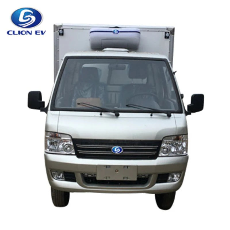 UAE golf cartz head-on studio shot of a silver electric refrigerated truck against a white background. This electric commercial vehicle shows the cab and the mounted white and blue refrigeration unit on top of the large cargo box. The image features the front grille, headlights, and mirrors of this specialized refrigerator delivery van for cold chain logistics.