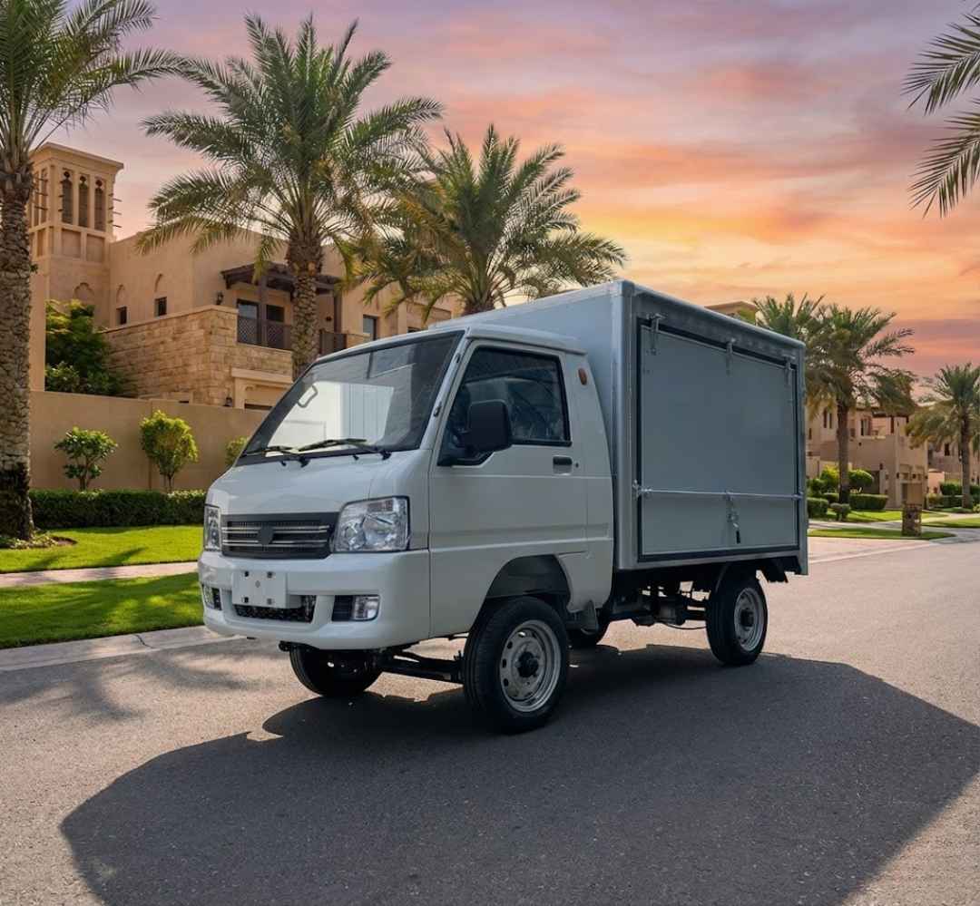White truck parked on a street with palm trees and a building in the background