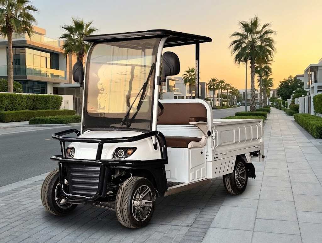 Electric golf cart on a paved path with palm trees and modern buildings in the background.