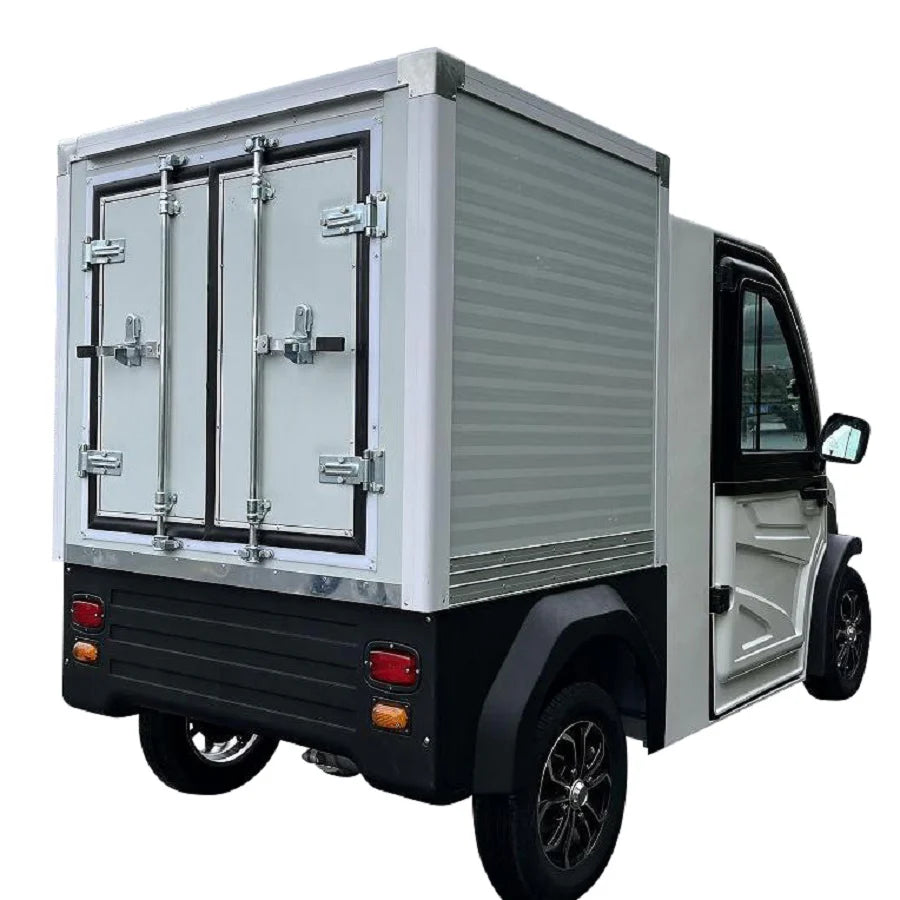 UAE golf cartz rear three-quarter studio shot of a white electric refrigerated delivery vehicle with an enclosed cab, set against a white background. This compact electric NEV or refrigerator work cart features a silver insulated rear cargo box with double doors and a black lower bumper. The vehicle has black fender flares and black custom wheels, highlighting its use for cold chain last-mile delivery.