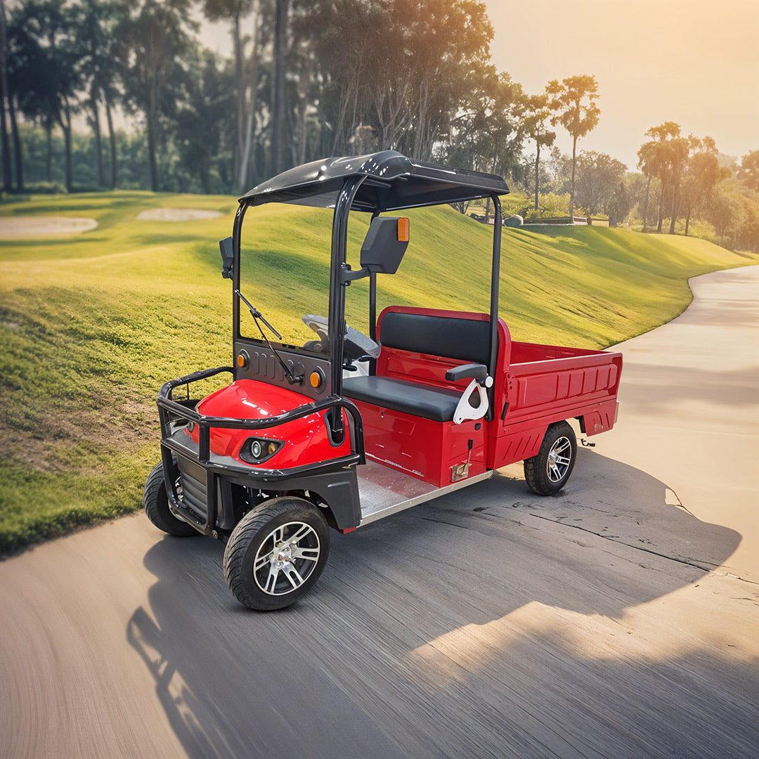 UAE golf cartz three-quarter front view of a red utility electric vehicle with a flatbed and a black roof, driving on a paved path. This two-seater work cart features black seats, a black front brush guard, and custom silver alloy wheels. The electric vehicle is designed for resort or commercial use and is pictured on a path winding through a sunny, lush green golf course or park.