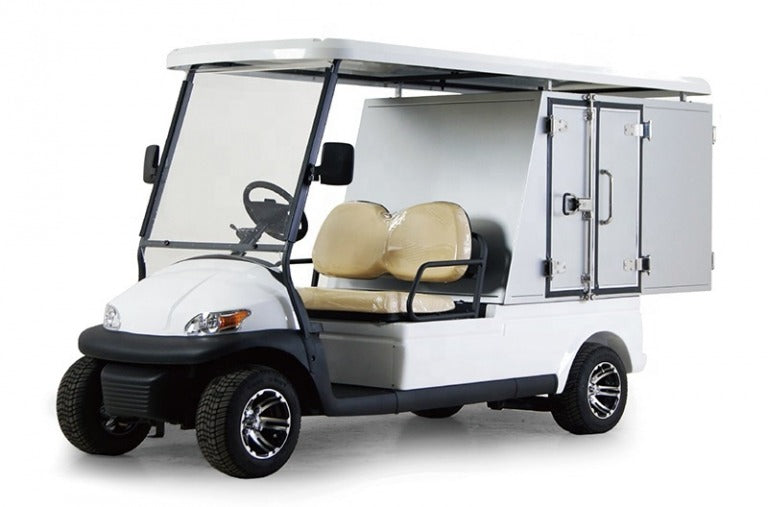 UAE golf cartz three-quarter front studio shot of a white two-seater utility golf cart with a white roof, set against a pure white background. This specialized electric work cart features tan seats and a rear compartment with two enclosed white storage cabinets with black handles. The service vehicle is equipped with all-terrain tires and custom black and silver wheels, highlighting its use for maintenance or delivery tasks.