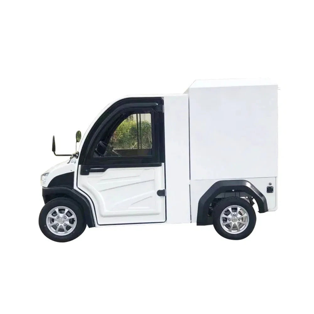 UAE golf cartz side profile studio shot of a white enclosed electric delivery vehicle with a large, box-style rear cargo area, set against a white background. This two-seater commercial NEV or electric utility truck features an enclosed cab with black window frames, a black roof, and small, multispoke silver alloy wheels. The vehicle is designed for efficient last-mile delivery and urban logistics.