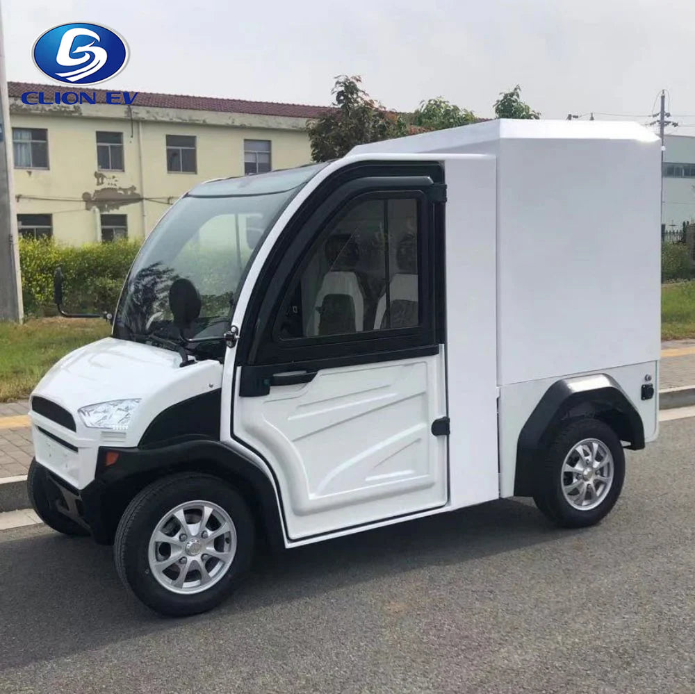 UAE golf cartz side view of a white enclosed electric delivery vehicle with a large rear cargo box, parked on an asphalt road. This two-seater commercial NEV or electric utility truck features black accents around the windows and fenders, a modern front end, and small, multispoke silver alloy wheels. The vehicle is designed for secure last-mile delivery and efficient urban logistics in a commercial or residential setting.