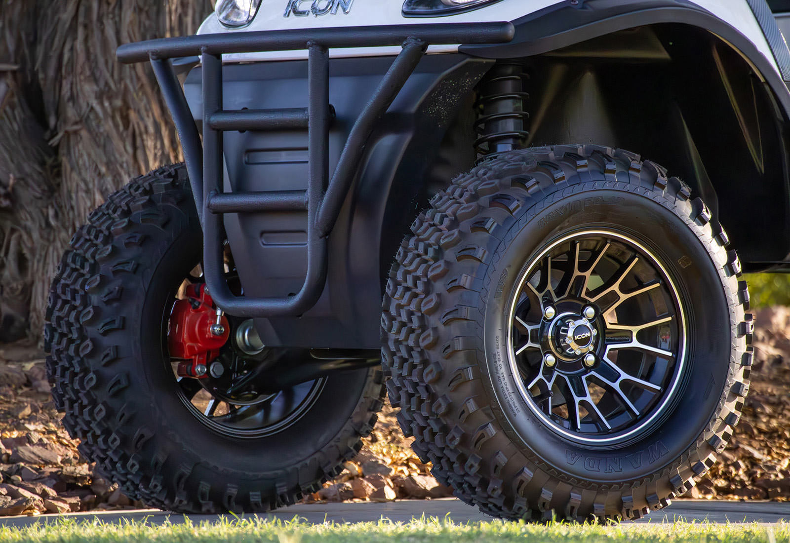 Close-up of a four-wheeler with large off-road tires and a black rim.
