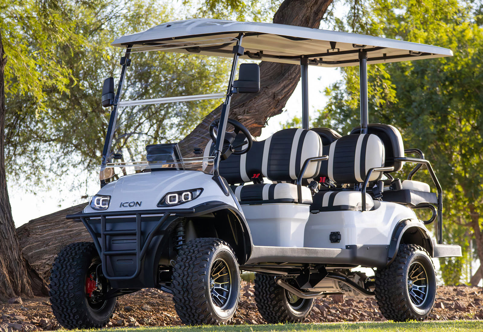 White golf cart with black seats in a natural setting